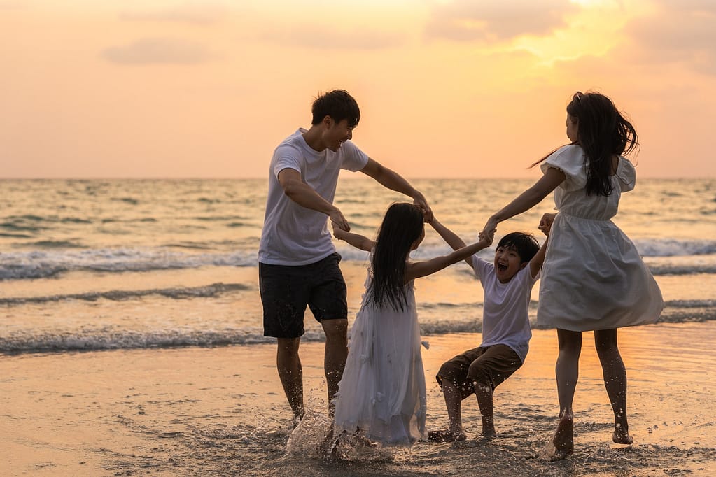 Asian young happy family enjoy vacation on beach in the evening. Family-Friendly Vacation Ideas