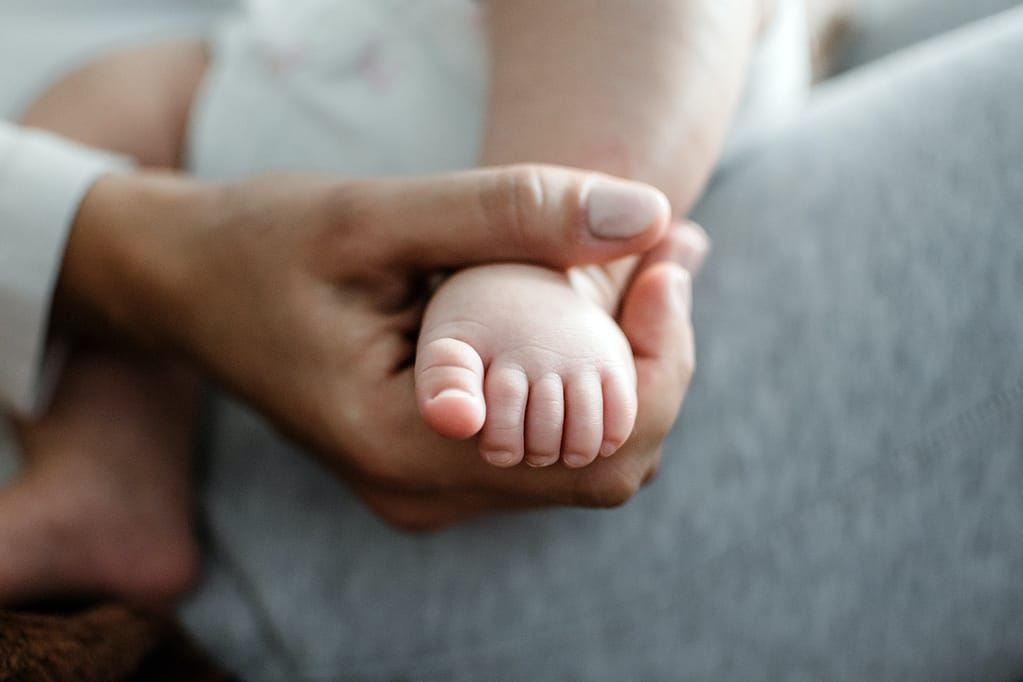 Life insurance. Health Insurance For Newborn Babies. Life Insurance for New Baby. Mother holding in hands feet of