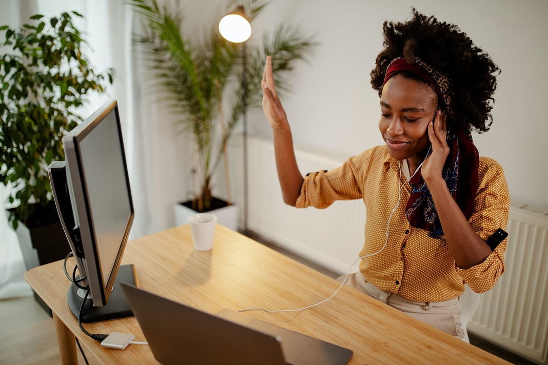 Freelance Afro American girl enjoys music in headphones.