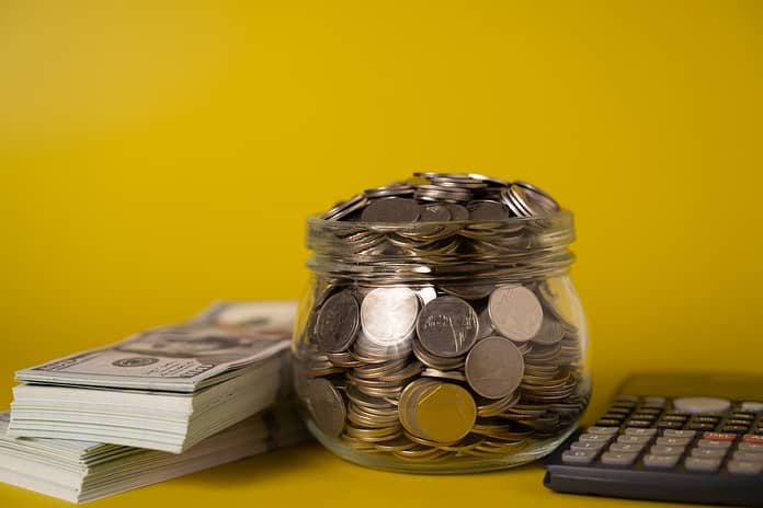 Banknotes and coins money in small glass jar for money saving, American dollars, Cash money dollars